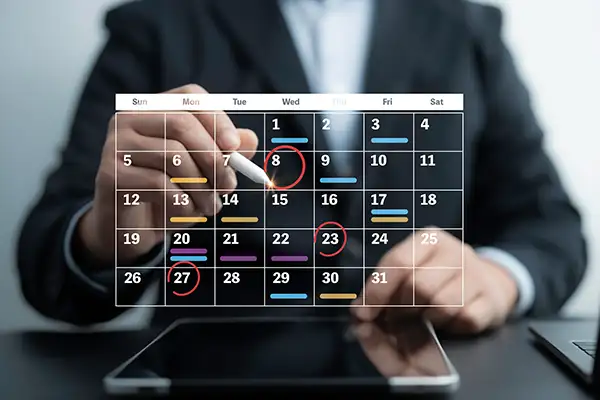Man in suit circling appointment dates on calendar