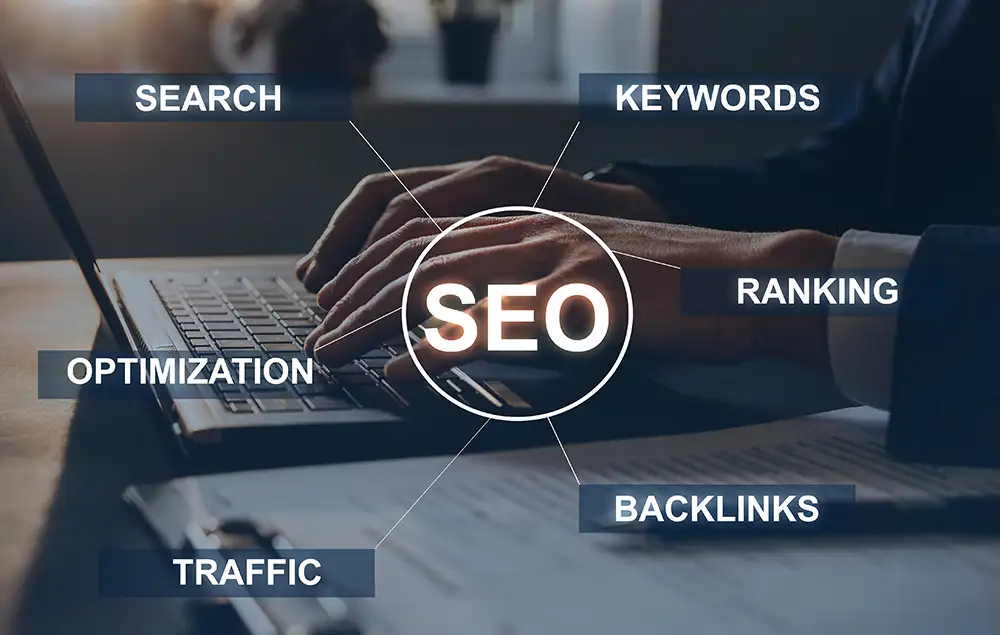 Hands typing on laptop with SEO in the middle, surrounded by the words 'search,' 'keywords,' 'ranking,' 'backlinks,' 'traffic,' and 'optimization' Hands typing on laptop with SEO in the middle, surrounded by the words 'search,' 'keywords,' 'ranking,' 'backlinks,' 'traffic,' and 'optimization'